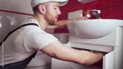 the plumber in working form shows a thumbs up that everything will be done photo