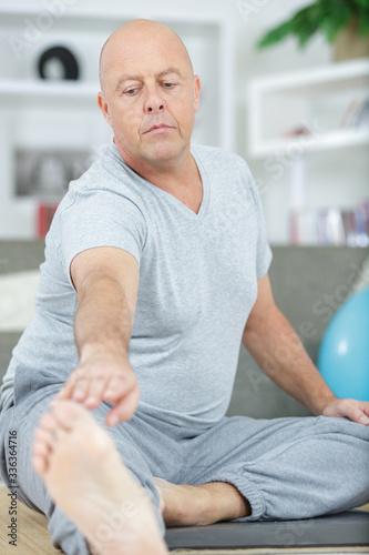 mature man stretching his leg