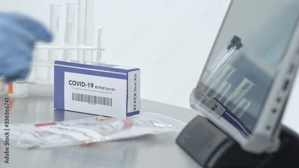 Lab technician using touchscreen processing covid-19 test kits during coronavirus outbreak. Lab technician using touchscreen processing covid-19 test kits during coronavirus outbreak.