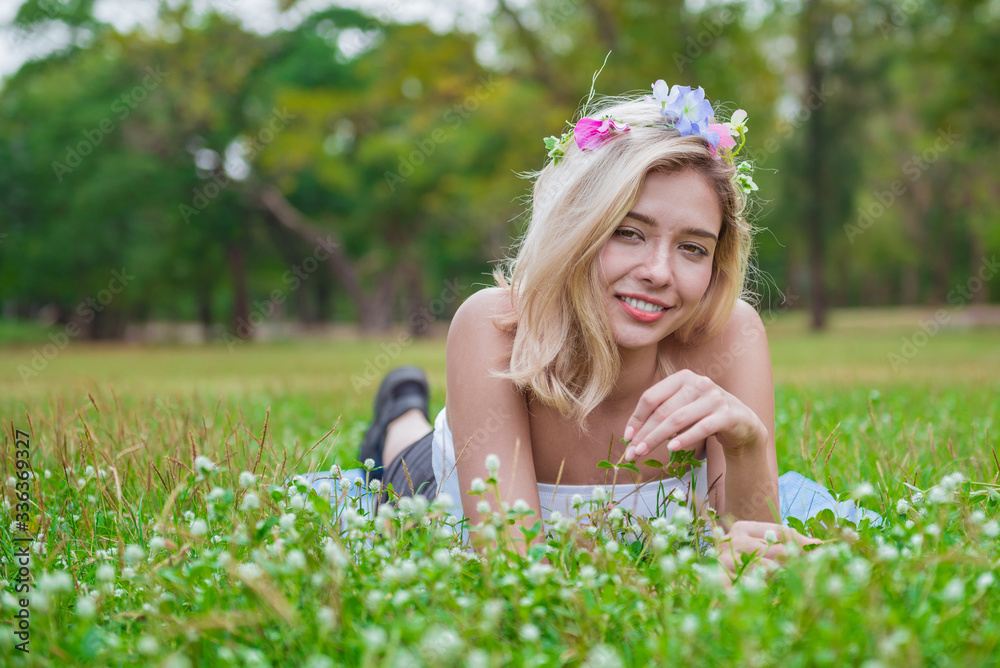 Pretty woman laying on the grass in spring park and smiling Pretty woman laying on the grass in spring park and smiling