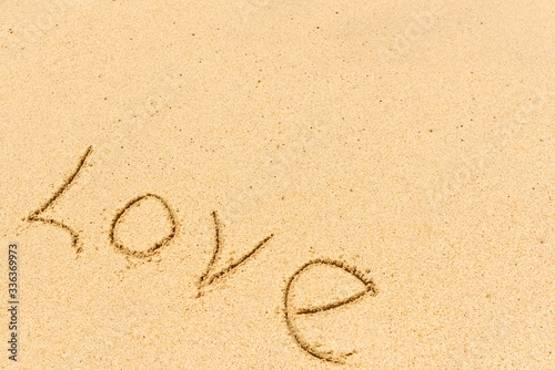 Close up love sign and wave on a sandy beach. Background close up.