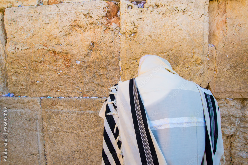 Orthodox Jew praying at the Western Wall, wearing the tallit prayer ...