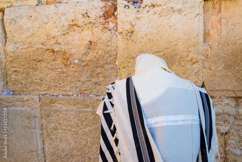 Orthodox Jew praying at the Western Wall, wearing the tallit prayer shawl photo