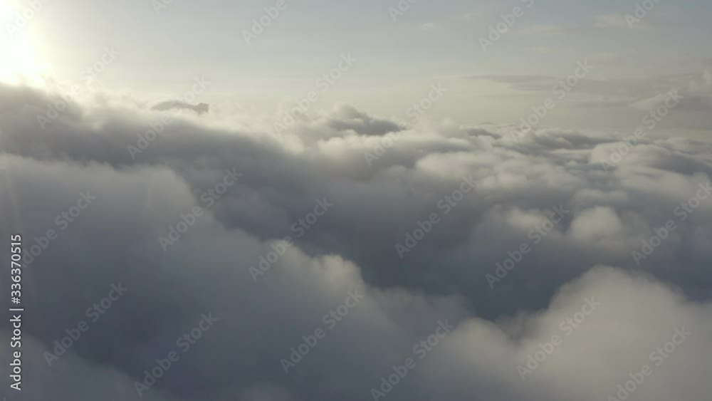 Drone Flight through Clouds with a mountain tip sticking out on the left of the shot Drone Flight through Clouds with a mountain tip sticking out on the left of the shot