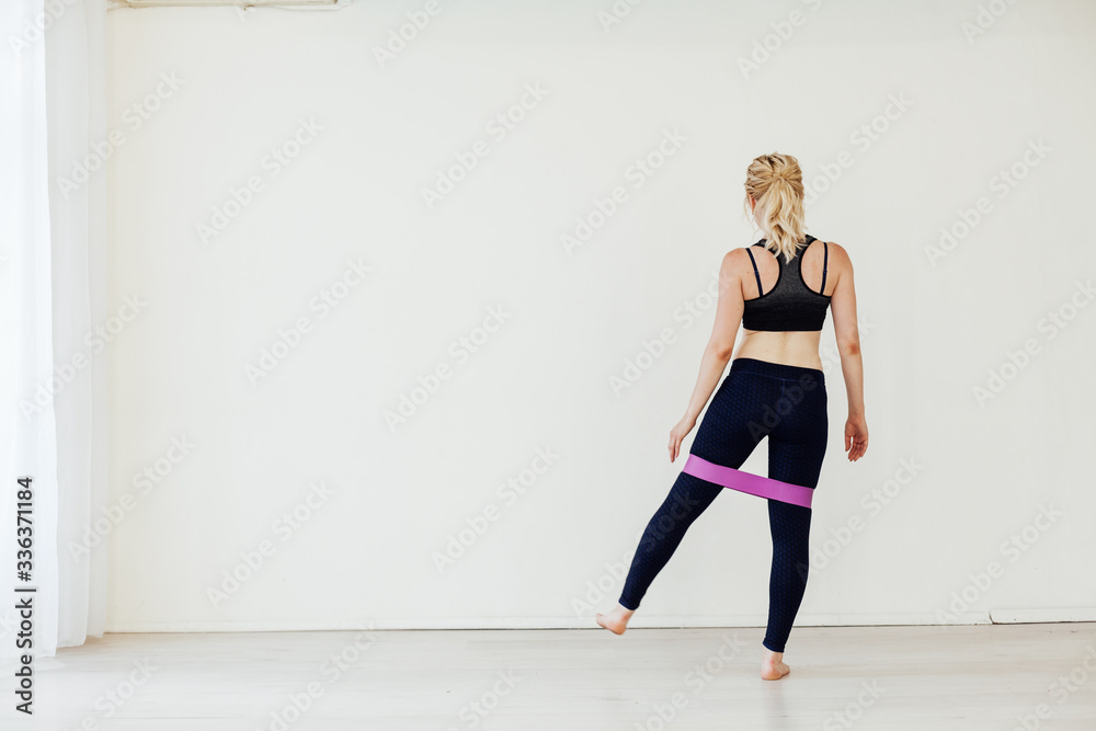 Obraz premium Beautiful athlete develops muscles with fitness gum