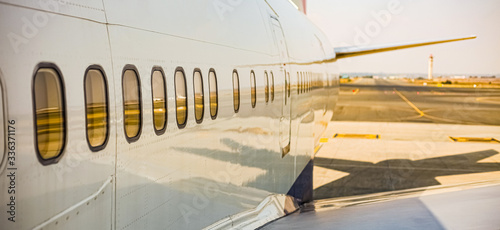 Airplane windows of a jumbo jet parked on the tarmac at an airport photo