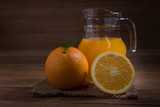 Orange juice in a glass and pitcher  on wooden background