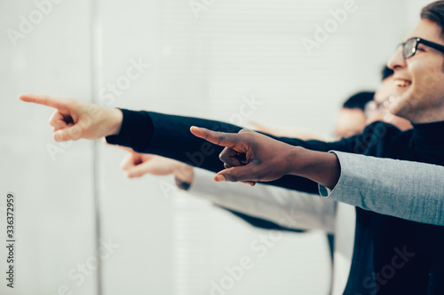 group of smiling business people pointing pointing forward © yurolaitsalbert