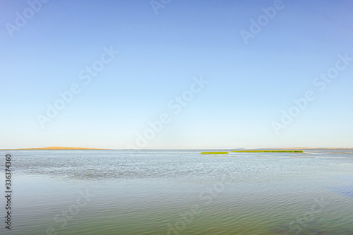 Calm water surface with clear blue sky. Akhtanizovsky estuary water landscape. Krasnodar region, Russia. photo