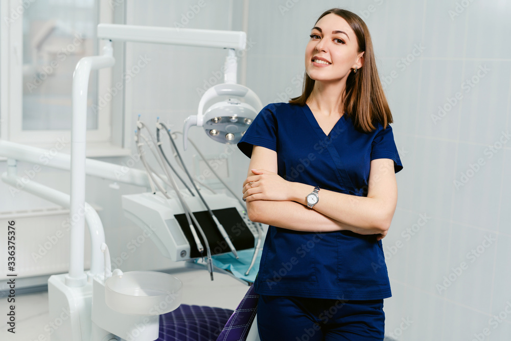Portrait of a smiling female dentist in the office of a modern dental clinic. Portrait of a smiling female dentist in the office of a modern dental clinic.
