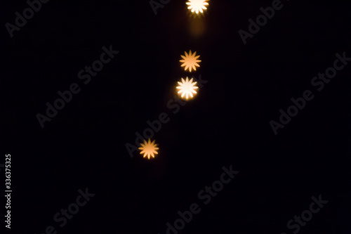 Abstract shining circular bokeh abstract for dark background. Blur yellow flower shape dots 