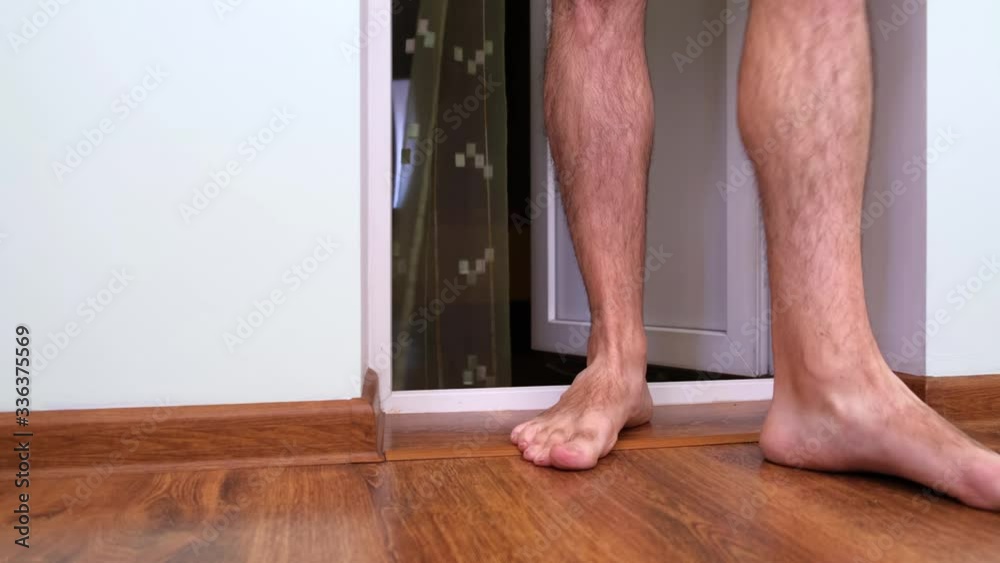Unsexy Man With Hairy Legs In Shorts Barefoot Crosses The Threshold Enters The Balcony Of A