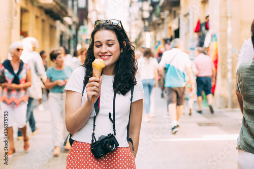 Young tourist woman enjoying an ice cream while exploring the city