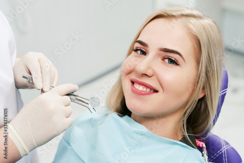 Smiling female patient looking at camera at dental clinic. Closeup cropped picture with copyspace