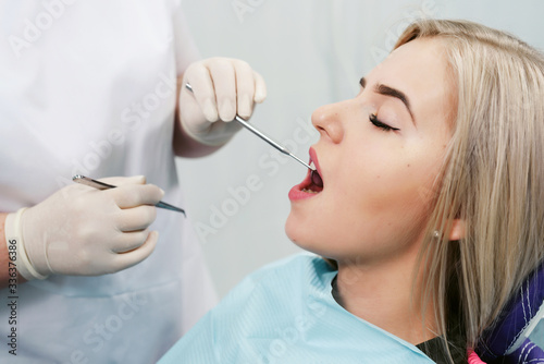 Dentist examining a patient s teeth in modern dentistry office. Closeup cropped picture with copyspace