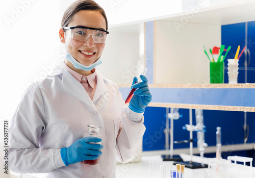 Front view of female scientist with surgical gloves posing in the lab