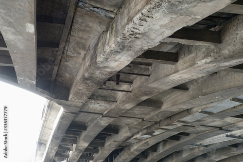 old weathered concrete beam under a bridge