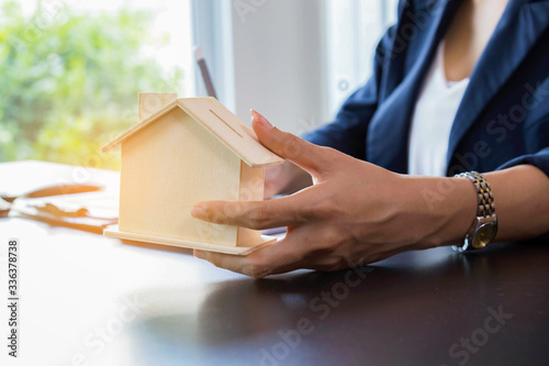 Close up hand of woman holding model house Concept of buying house