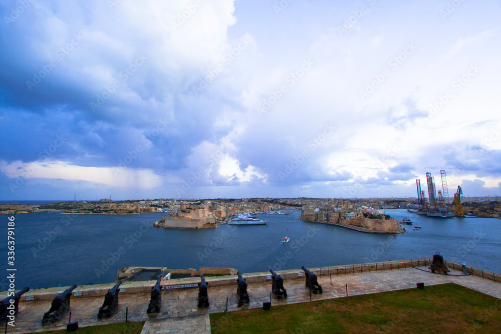 The 16th century Saluting Battery at the lower tier of St. Peter & Paul Bastion overlooking Fort St. Angelo and the Grand Harbour in Valletta, Malta The 16th century Saluting Battery at the lower tier of St. Peter & Paul Bastion overlooking Fort St. Angelo and the Grand Harbour in Valletta, Malta