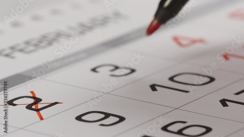 CLOSE UP: Crossing out a numbers in a paper calendar
