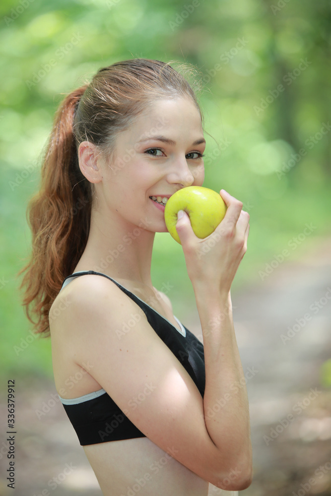 Jeune femme sportive mangeant une pomme Jeune femme sportive mangeant une pomme