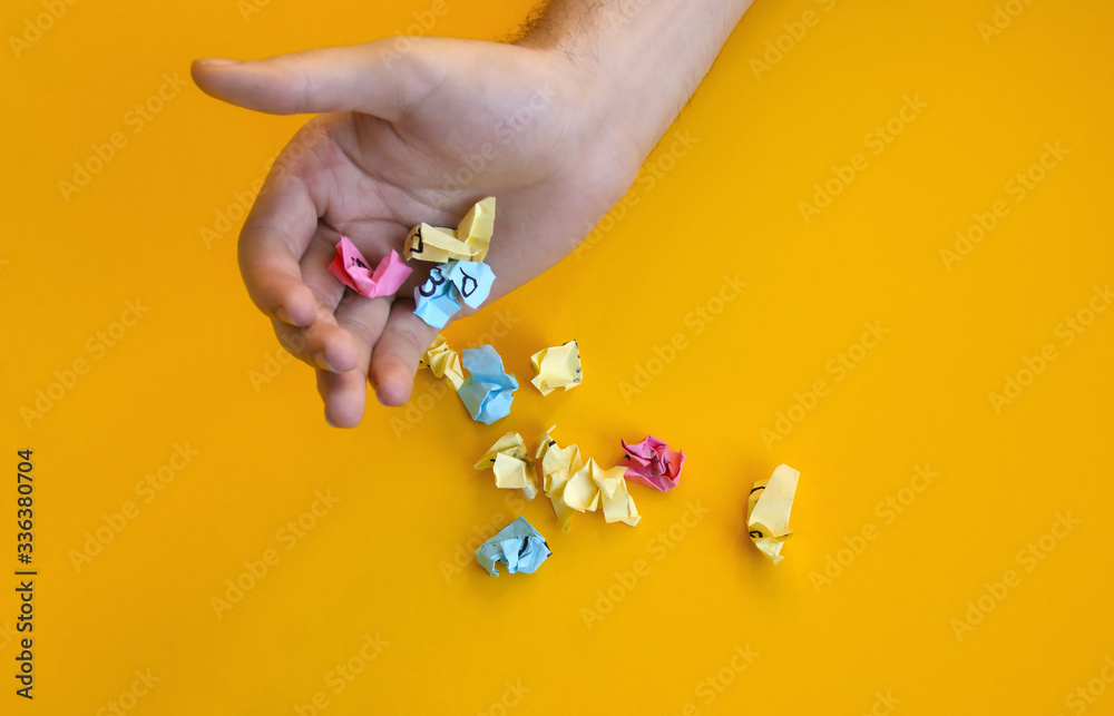 The male hand wrinkled all his notes on the stickers. Scattered on a yellow background