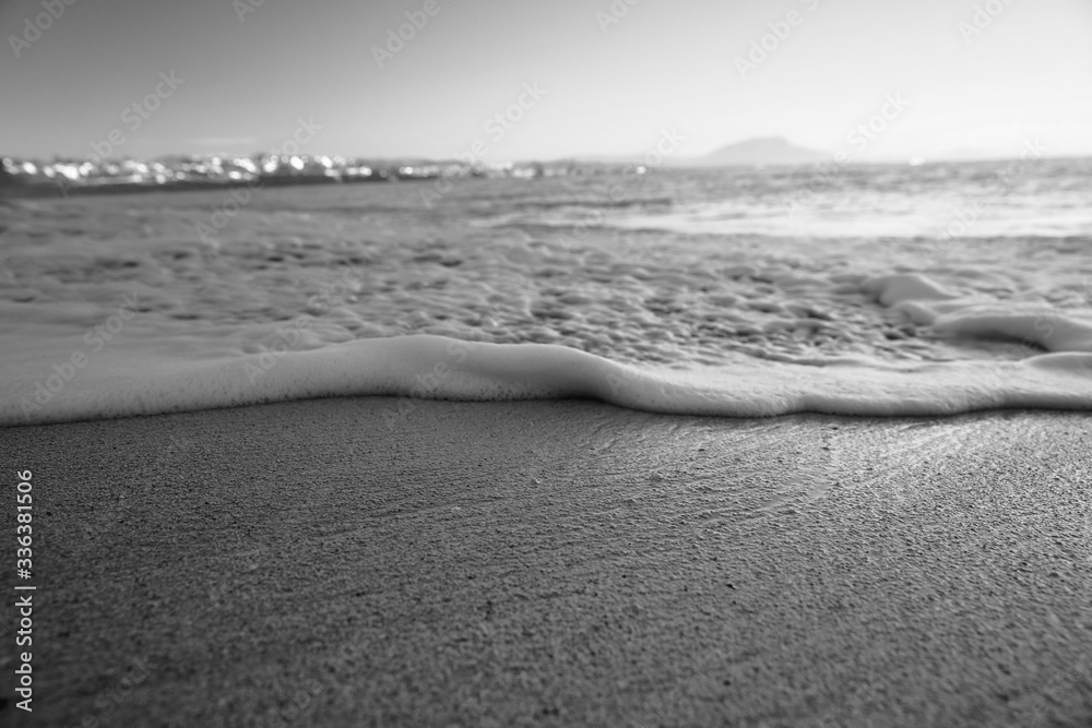 Obraz premium Wave On Sandy Beach. Background. Splash of waves on the sandy beach. foam, surf, waves.