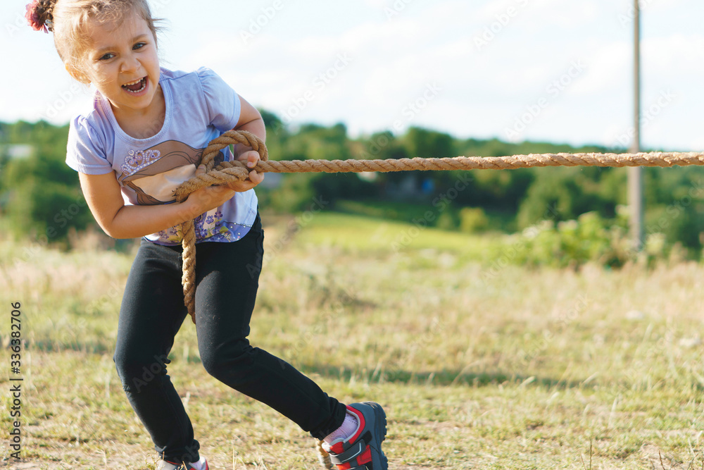 Fototapeta premium laughing girl pulling rope