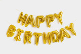 Happy birthday lettering made of golden balloons on a white background.