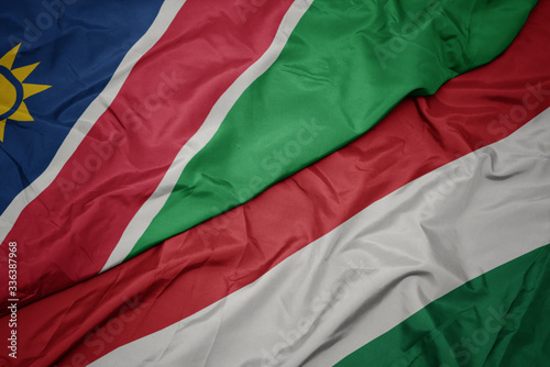 waving colorful flag of hungary and national flag of namibia.