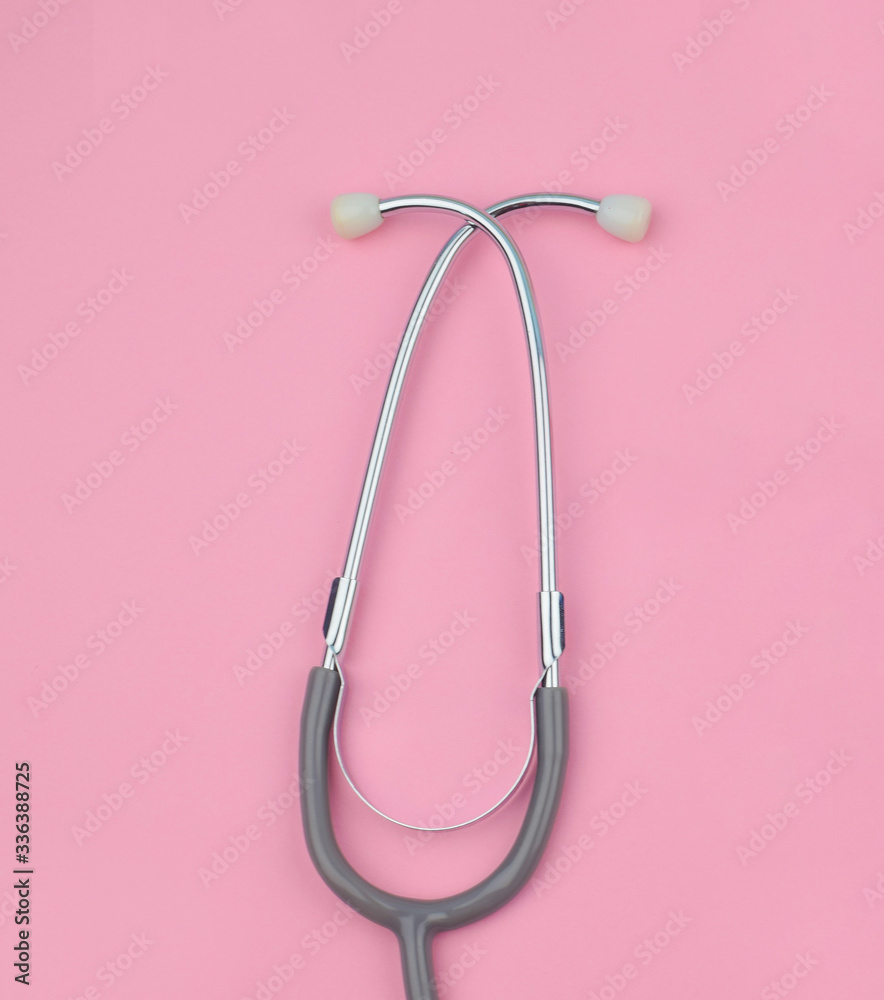 Half of one single normal stethoscope isolated on top of a pink color paper background Half of one single normal stethoscope isolated on top of a pink color paper background