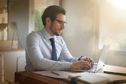 Valokuva boss in home confinement working on his laptop