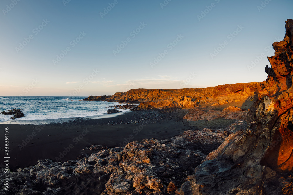 Coastline with lava cliffs and ocean at sunset in Lanzarote, Canary Islands. Coastline with lava cliffs and ocean at sunset in Lanzarote, Canary Islands.