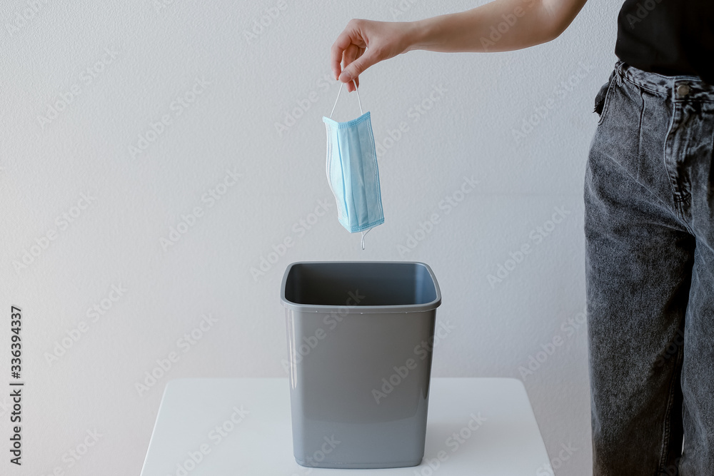 hand throws a protective mask into a bucket hand throws a protective mask into a bucket