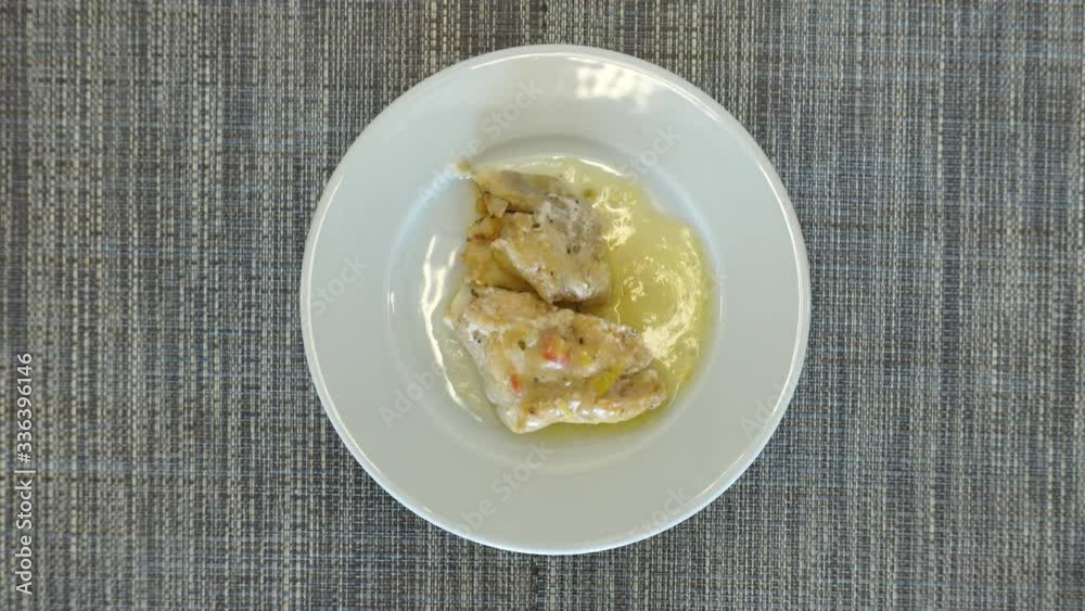 Top view, white fish fillet with sauce as a dish for lunch. The plate rotates. Tasty and healthy food concept. Top view, white fish fillet with sauce as a dish for lunch. The plate rotates. Tasty and healthy food concept.
