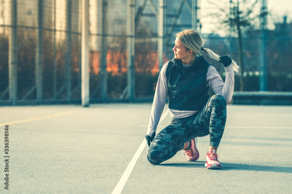 Young Caucasian woman taking a exercises break, kneeling on one leg Young Caucasian woman taking a exercises break, kneeling on one leg