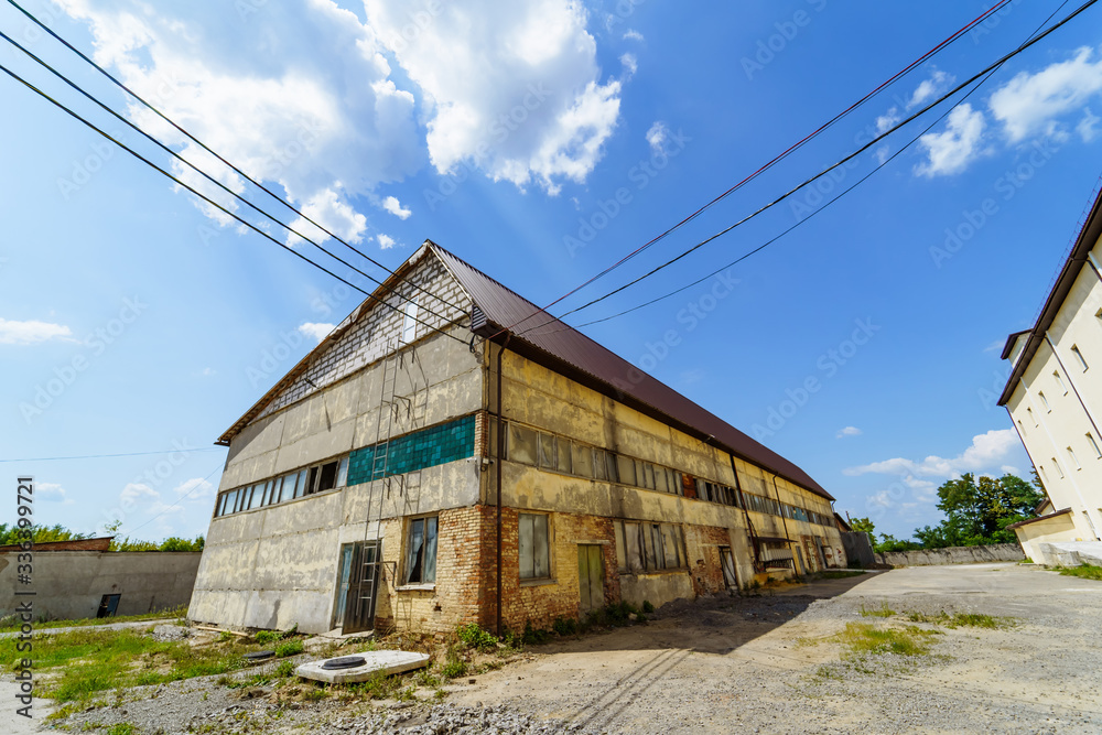 Abandoned factory house. Old industrial building outdoor view on sunny summer day.