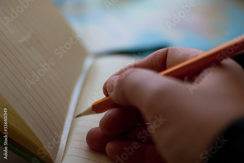 A young girl's hand writes in a diary, taking notes. A young woman makes a list. A woman's hand is writing in a blank notepad with a pencil