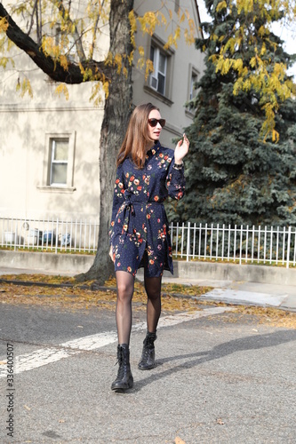 A female model in a dress walks down a street in Brooklyn