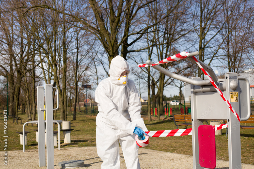 Fototapeta premium Kobieta w odzieży ochronnej zabezpiecza sprzęt sportowy w parku przy użyciu taśmy bezpieczeństwa