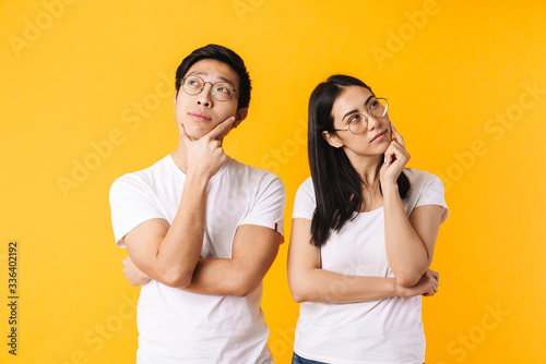 Image of serious multinational man and woman thinking and looking aside