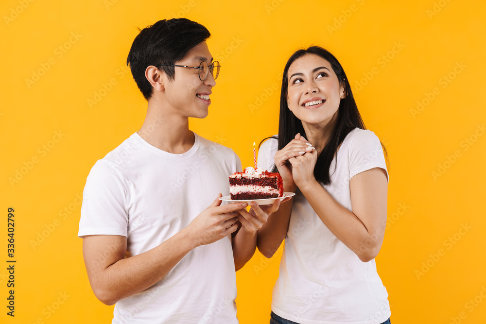 Image of multinational couple holding cake while celebrating birthday Image of multinational couple holding cake while celebrating birthday
