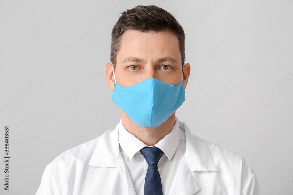 Doctor in protective medical mask on grey background Doctor in protective medical mask on grey background