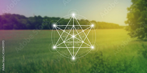Merkaba sacred geometry spiritual new age futuristic illustration with interlocking circles, triangles and glowing particles in front of blurry natural photographic background
