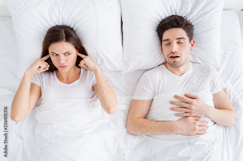 Tableau sur toile High angle above view photo of pretty lady covering ears handsome snoring guy co