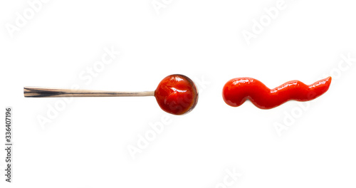 Spoon with ketchup and tomato sauce splash isolated on white background, top view. Close-up seasoning and dip