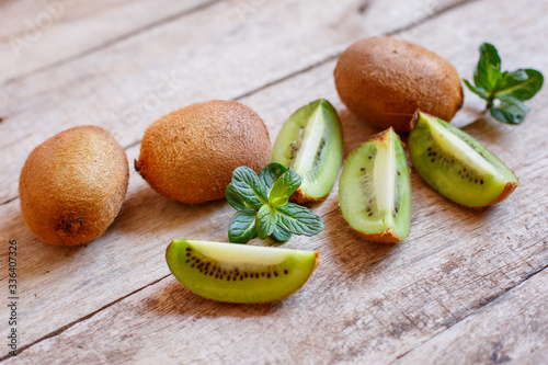 fresh Kiwi and kiwi slices with mint on a wooden background
