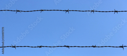 Barb wire fence with blue sky in the background