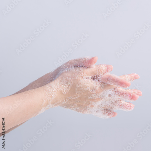 Washing hands. Asian young woman using liquid soap to wash hands  concept of hygiene to protective pandemic coronavirus isolated on gray white background  close up.