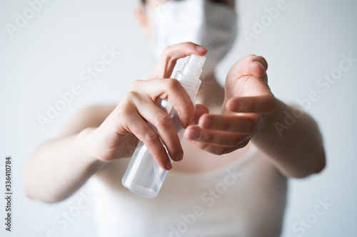 COVID-19 Close up woman hands using wash hand sanitizer gel dispenser, against Novel coronavirus (2019-nCoV) at home.